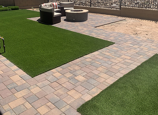 seating space with paver walkways and artificial turf