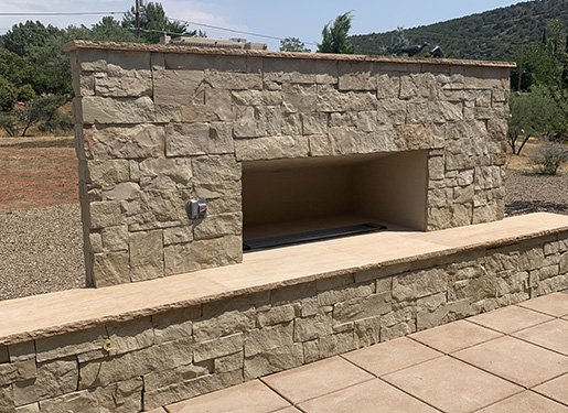 outdoor stone fireplace and wall feature